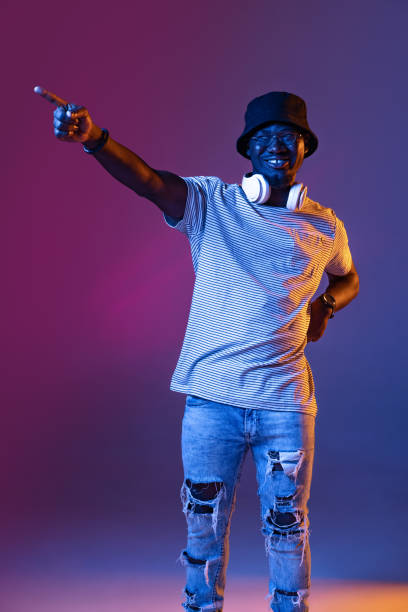 istock Winning success happy man celebrating being a winner. Dynamic image of male model on gradient purple pink studio background in neon 1350812883