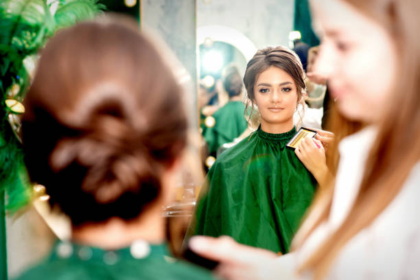 istock Make-up artist doing makeup for young beautiful bride applying wedding makeup in a beauty salon. 1350812995