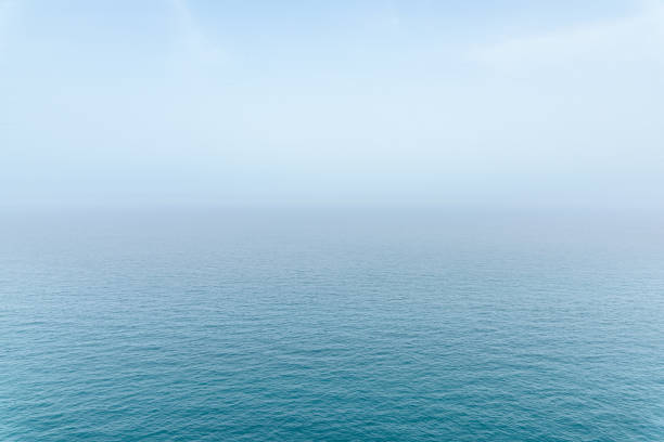 Abstract infinity sea view with small wave pattern and fog on horizon, clear sky in Puglia, Italy