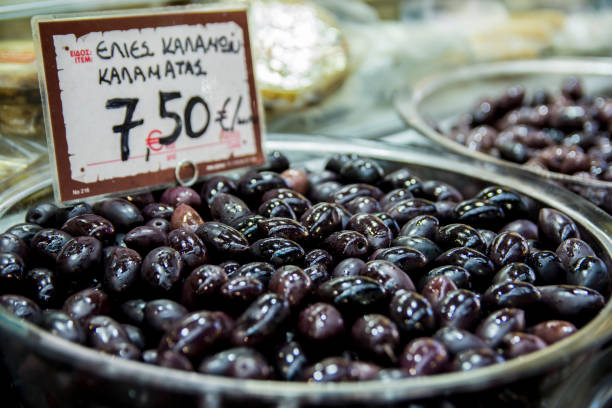 uma pilha de azeitonas kalamata à venda (em grego: "azeitonas de kalamata") em um mercado em tessalônica, grécia - calamata olive - fotografias e filmes do acervo