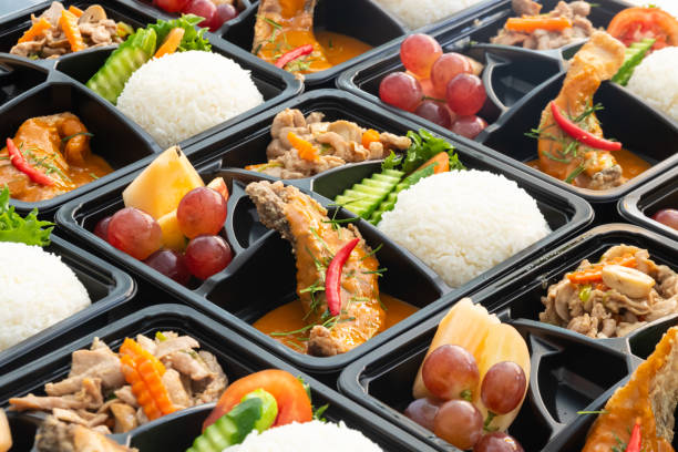 istock Thai food lunch boxes in plastic packages. Rice salmon with red curry. 1350814610