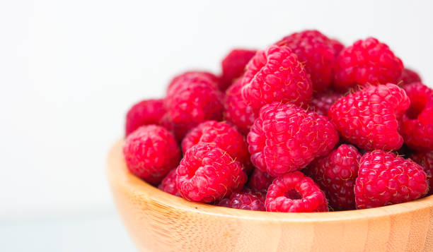 istock Fresh red raspberry in old wooden plate, copy space 1350814779