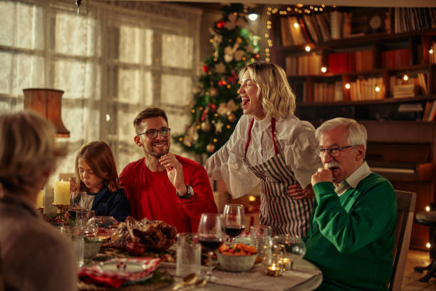 Joyful family celebrating Christmas at dining table. stock photo