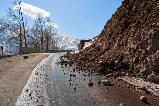 Early spring in the mountains. The rocks fell on the road. Dangerous bugle road. Rockfall in the mountains.
