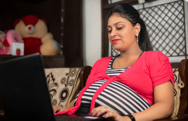 집에서 노트북에서 일하는 편안한 임신 한 인도 여성. - human pregnancy physical activity women india 뉴스 사진 이미지