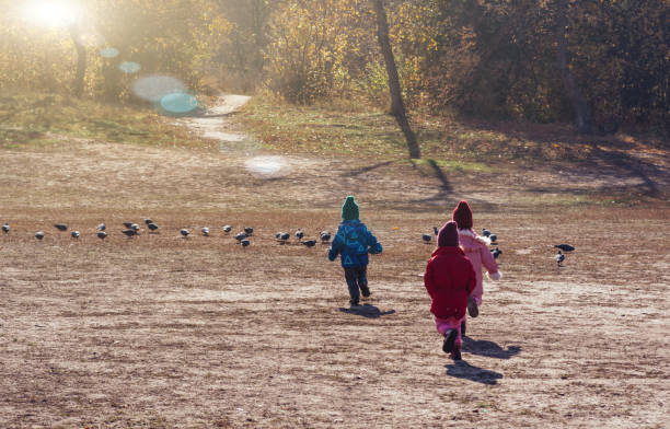 istock Children play in nature. People from the back 1350817251