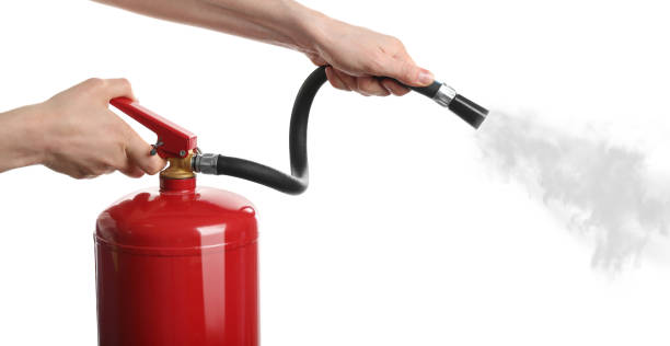 Woman using fire extinguisher on white background, closeup Woman using fire extinguisher on white background, closeup fire extinguisher photos stock pictures, royalty-free photos & images