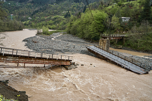 A bridge over a mountain river destroyed by water.