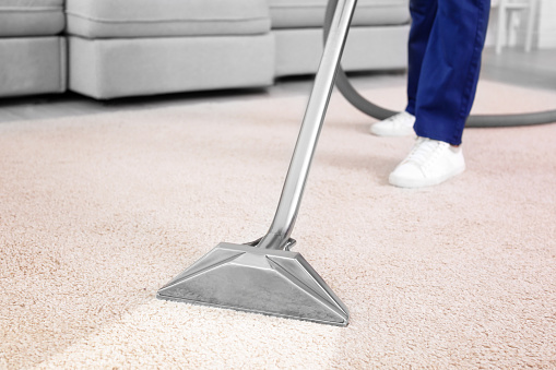 Trabajador eliminando la suciedad de la alfombra en interiores, primer plano. Servicio de limpieza photo