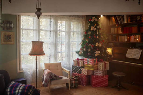 Brightly lit christmas tree with ribbons and ornaments fills the foreground on the left leading back to a livingroom fireplace with stockings and wreathhttp://i1136.photobucket.com/albums/n486/Ron_Patty/Christmas_zps36a79558.jpg