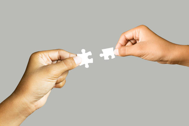 istock Close up holding one puzzle element connected isolated on gray background. High-resolution product. 1350817802