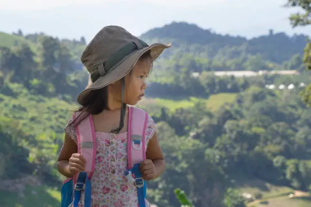 Little asian kids hiking mountain. Child mountaineer having fun while climbing a mountain with a backpack.