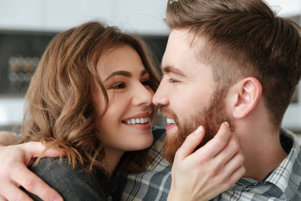 istock Happy loving couple sitting on sofa indoors 1350823830
