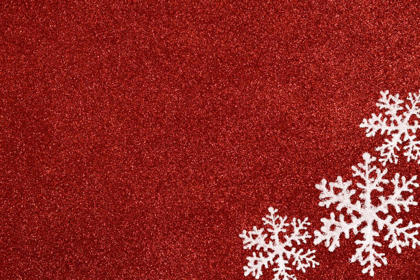 istock Three white snowflakes on a glitter red background. 1350825495