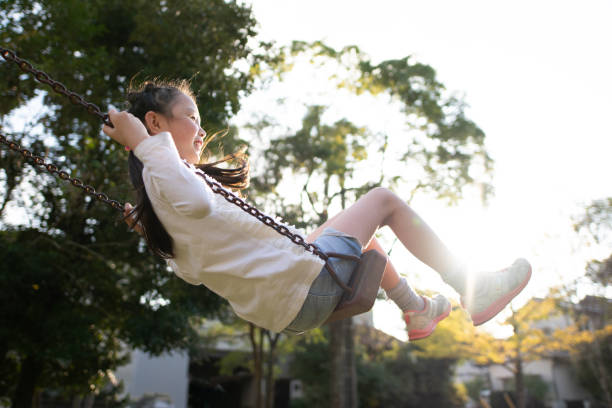 istock Girl playing on a swing 1350825540