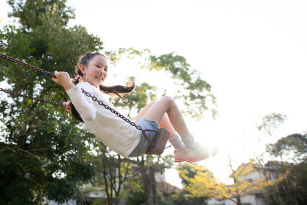 istock Girl playing on a swing 1350825544