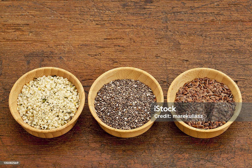 3 bowls of seeds, chia, flax & hemp, on rustic wooden table chia, flax and hemp healthy seeds in small wooden bowls Chia seed Stock Photo