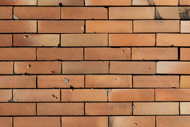 istock Old orange brick wall with holes and cracks background 1350826023