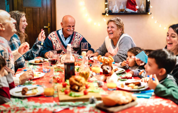 wielopokoleniowa rodzina bawiąca się na świątecznej kolacji - ferie zimowe i x mas koncepcja o dziadkach jedzących razem z dziećmi na kolacji domowej - skup się na babci po prawej stronie - large family zdjęcia i obrazy z banku zdjęć