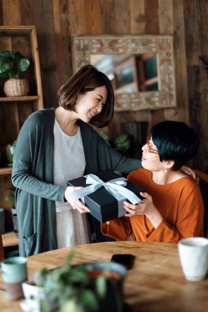 집에서 딸로부터 선물을 받는 아시아의 한 선임 어머니. 어머니와 딸 사이의 사랑. 주고 받는 기쁨 - living room people joy happiness 뉴스 사진 이미지