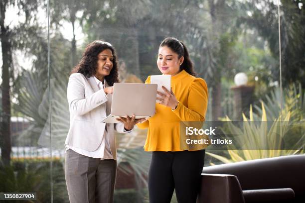 Two Businesswomen Using Laptop And Digital Tablet At Office Stock Photo - Download Image Now