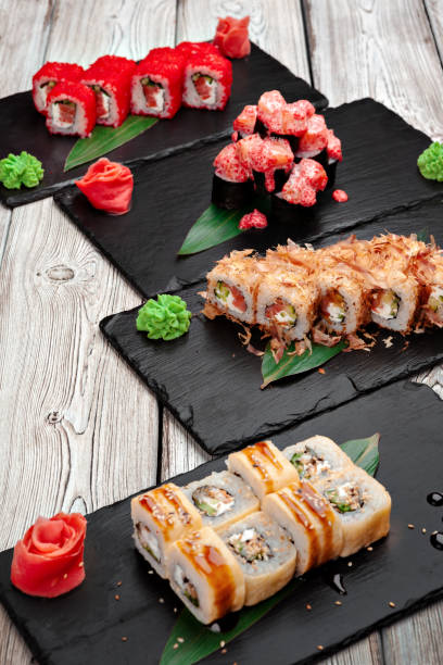 istock Sushi rolls served on boards on dark wooden background 1350828630