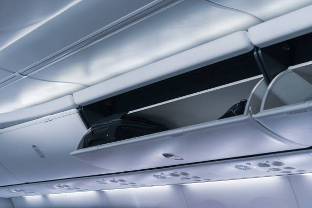 istock Baggage on cabin locker overhead on airplane flight 1350830190