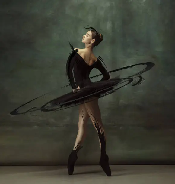 Sense of pride. Cinematic portrait graceful female ballet dancer posing isolated on dark vintage studio background with drawings. Art, motion, action, inspiration concept. Artwork