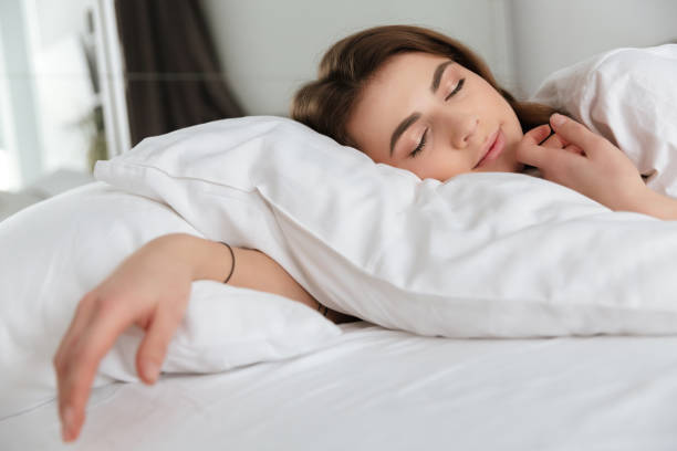 istock Tired smiling woman sleeping. 1350830730