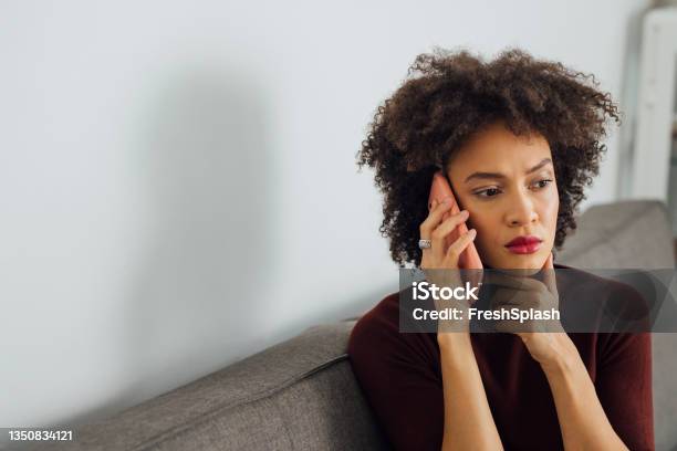 Worried Business Woman Talking On A Mobile Phone At Home Stock Photo - Download Image Now