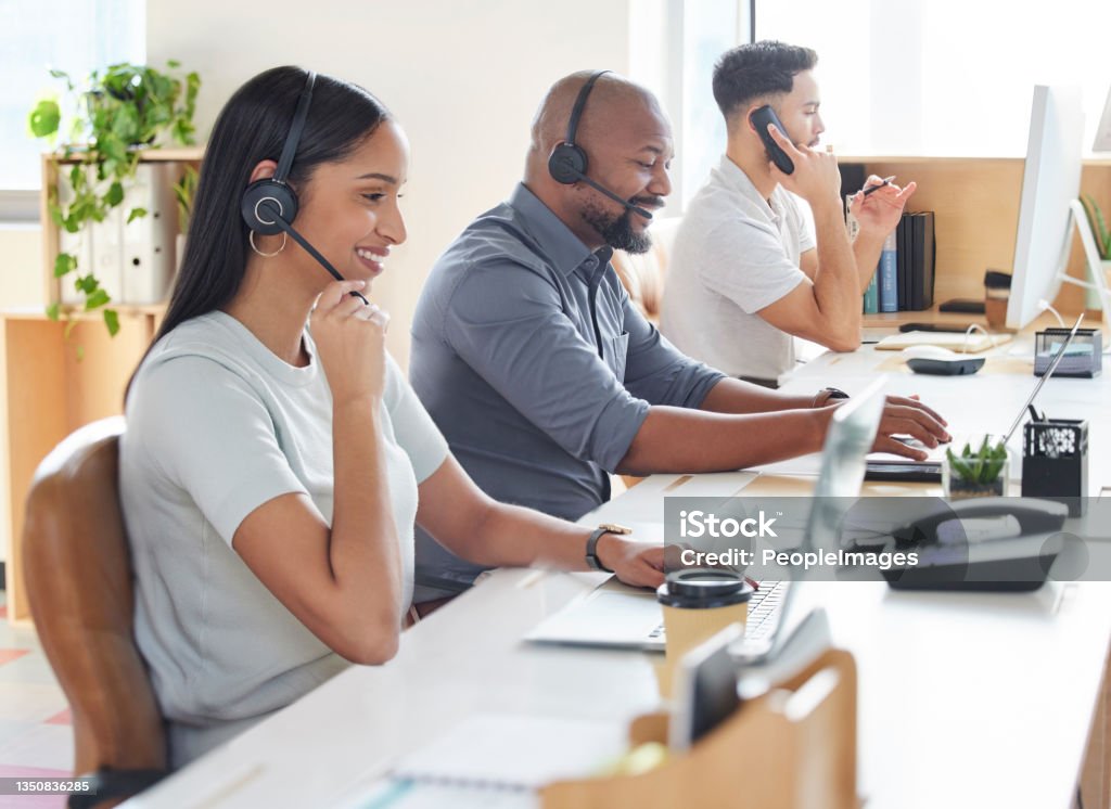 Shot of a group of businesspeople working in a call centre Responding as quickly as possible to all inquiries Call Center Stock Photo
