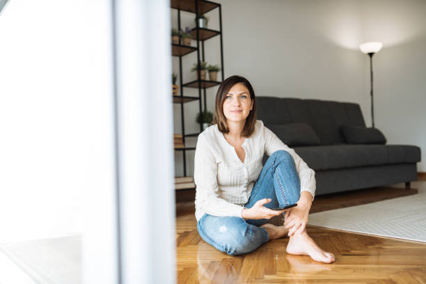istock Mid adult woman using digital technologies in new home - using mobile app on smart phone 1350838771