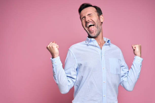 istock Man on pink background with hand raised 1350839904