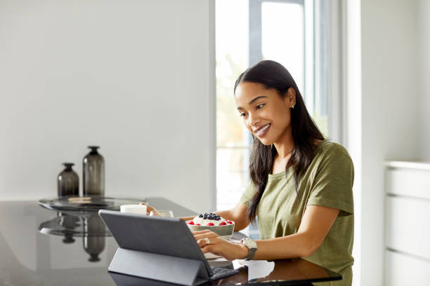 istock Woman watching movie on tablet PC during breakfast 1350841410