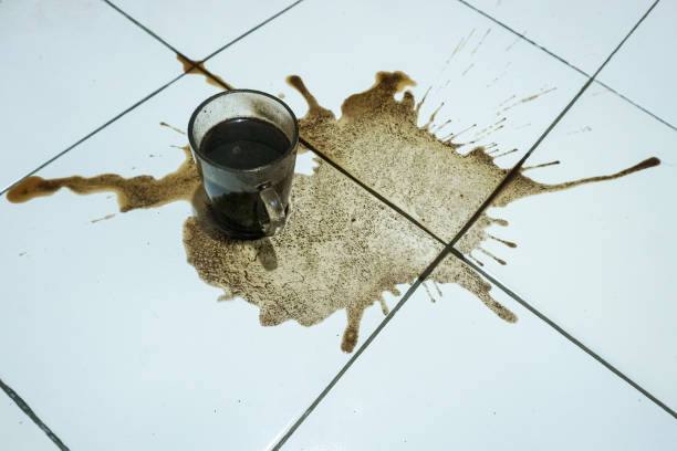 istock Black coffee spills from glass cup 1350841861