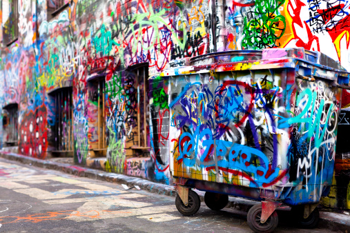 Building and dumpster covered in graffiti in a Melbourne lane