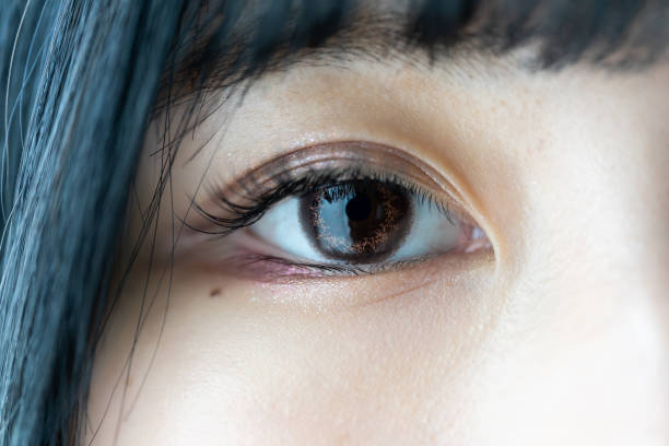 Eye of young Asian woman, colored contact lens in her eyes stock photo