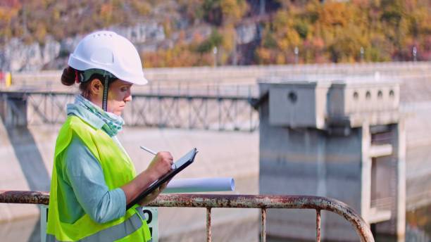 Maintenance female engineer working in hydroelectric power station. Renewable energy systems.