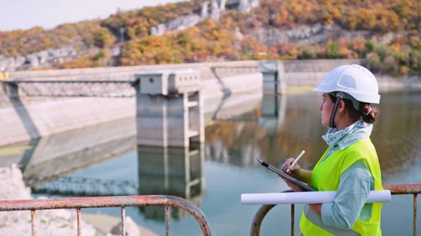 수력 발전소에서 일하는 유지 보수 여성 엔지니어. 재생 가능 에너지 시스템. - dam 뉴스 사진 이미지