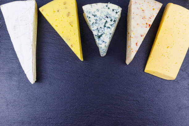 istock Set of various types of cheese on black slate background. Top view 1350849809