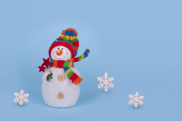 istock Cute Snowman with white flakes on blue background. Winter holiday concept. 1350850310