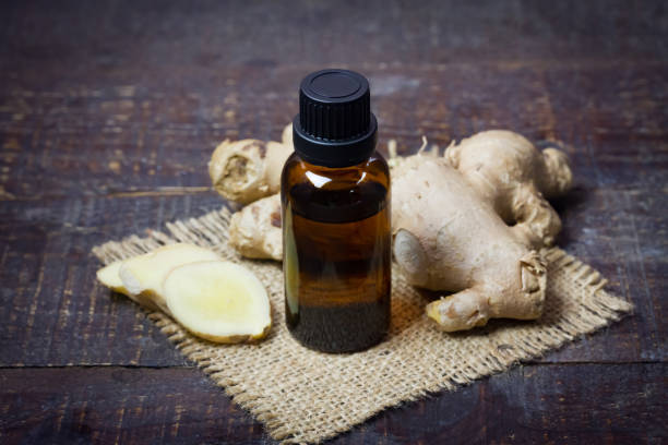 istock Ginger essential oil in bottle and fresh ginger with sliced on rustic wooden background. 1350851386