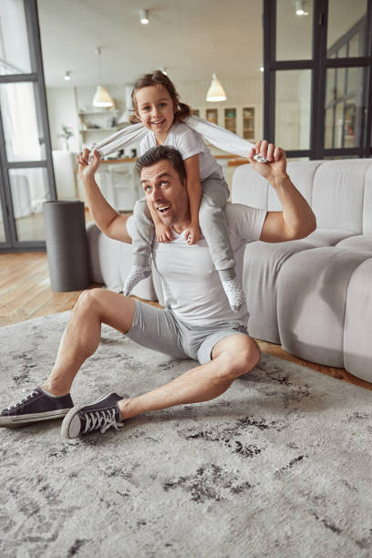 istock Cheerful man cudling with his daughter at home 1350853350