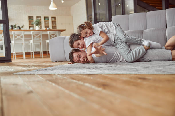 istock Funny dad with kids on back in living room 1350853393