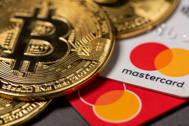 Antalya, Turkey - November 1, 2021: Bitcoin cryptocurrency standing on a MasterCard credit card. stock photo