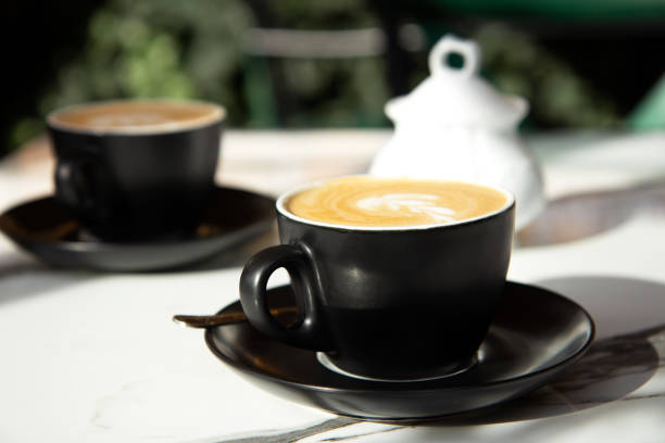 istock Two black ceramic cup of coffee on a marble table on an open terrace 1350855074