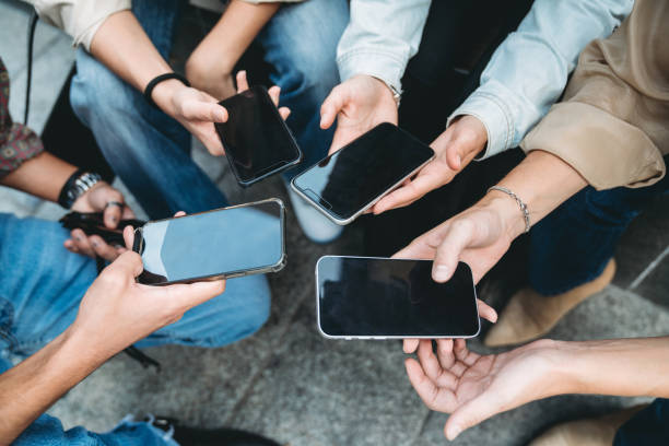 istock Four friends are sharing informations with smart phones 1350856501