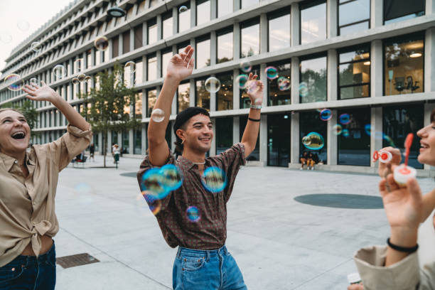 istock Friends playing with soap bubbles together in the city 1350856561