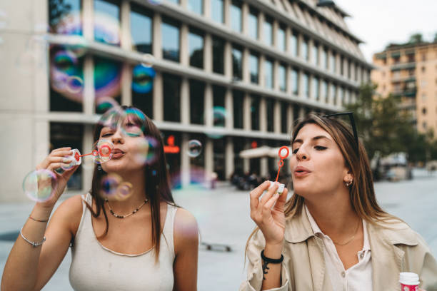 istock Two friends are playing together with bubble wand 1350856563