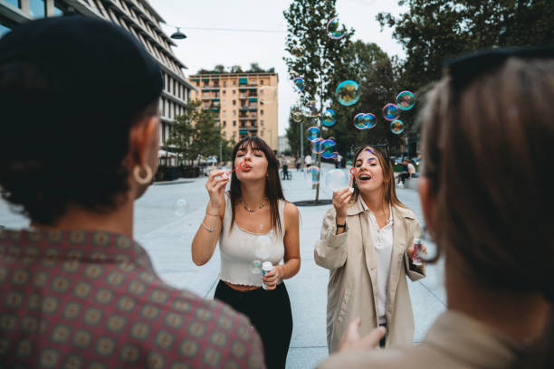 istock Friends playing with soap bubbles together in the city 1350856564